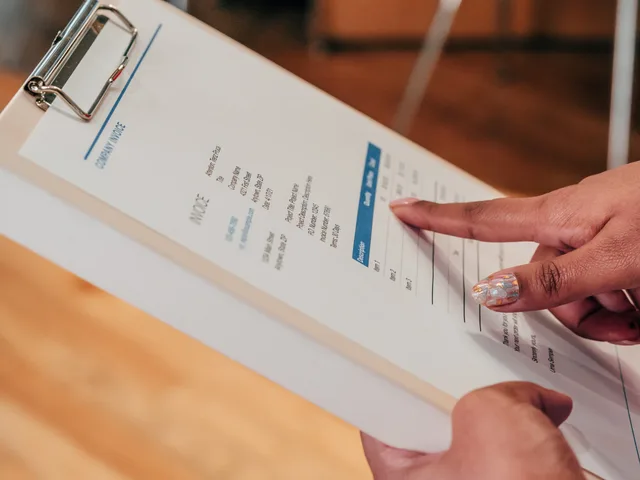 Close-up image of a person pointing to a document on a clipboard, indoors. Documenti e verifiche per acquistare da un fornitore: checklist operativa